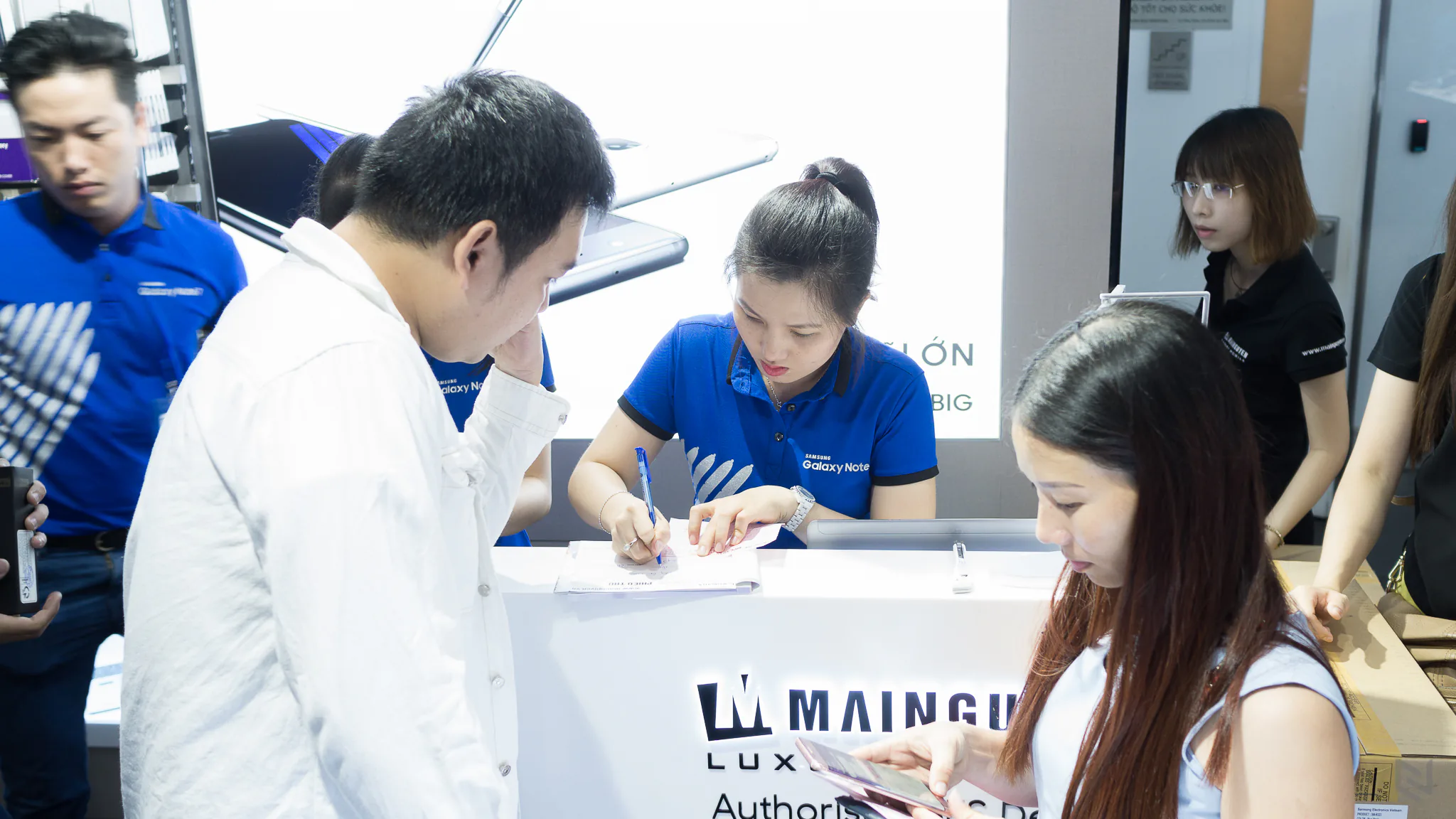 Nhân viên Samsung làm thủ tục giao máy cho khách