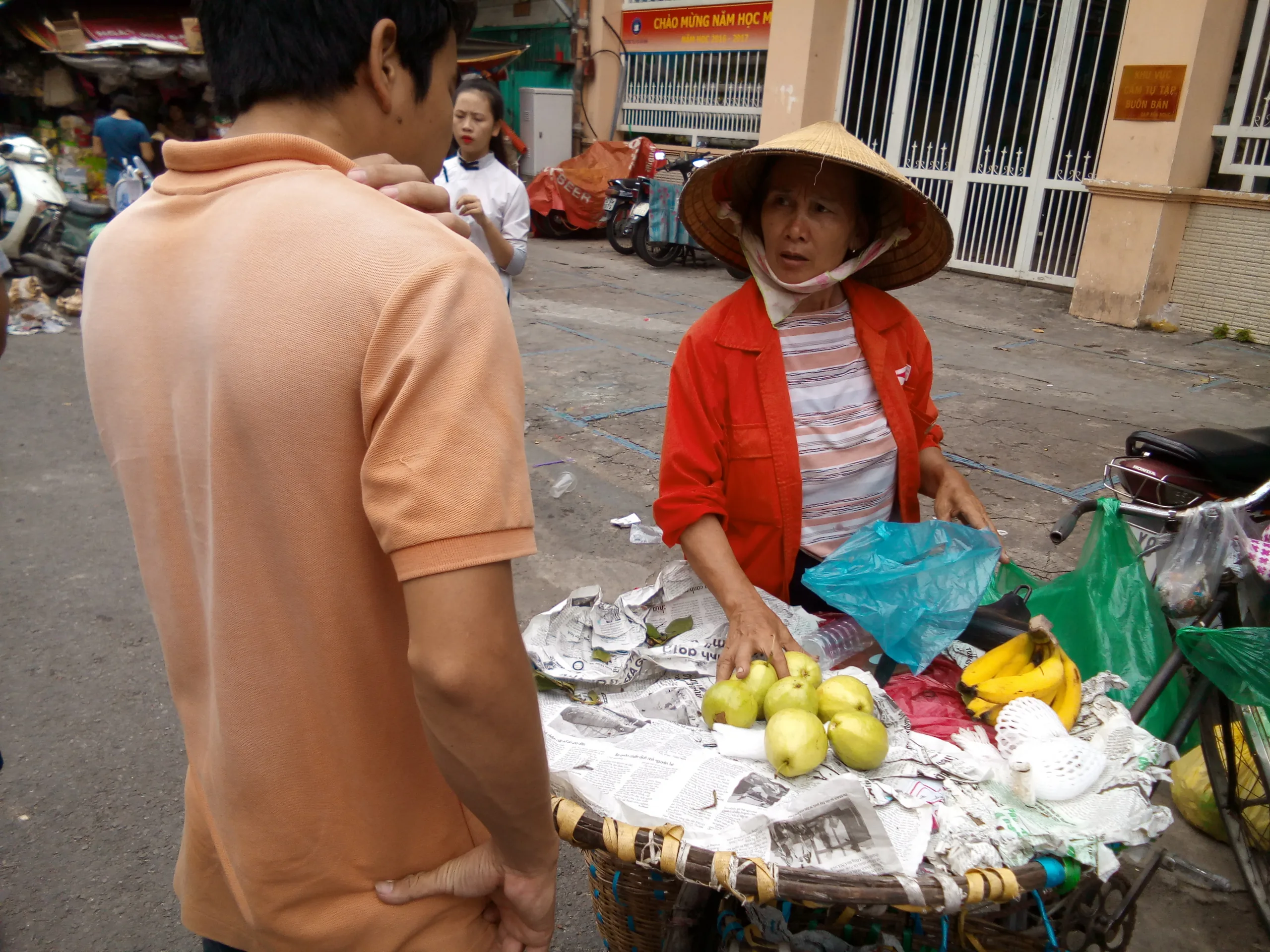 Anh chàng này đang cố trả giá với cô mấy trái xoài. Mình tiện đi ngang qua bất chợt giơ máy lên chụp luôn